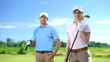 © motortion - Beautiful female with golf club and sport coach smiling on camera, free lessons