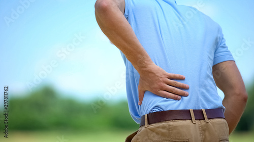Fotomural Male feeling sharp lower back pain outdoor, health and problems, medicine