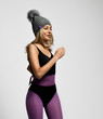 © Dmitry Lobanov - Portrait of athletic blonde girl in purple sports wear and gray winter hat with furry pompon is running jogging