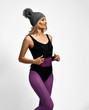 © Dmitry Lobanov - Portrait of happy athletic blonde girl in purple sports wear and gray winter hat with furry pompon enjoying running