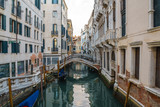 Fototapeta Miasto - Boats on narrow canal between colorful historic houses in Venice.