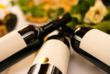Wine Bottles Exposed During A Tasting With Corks And Decoration On White Tablecloth With Green Plants