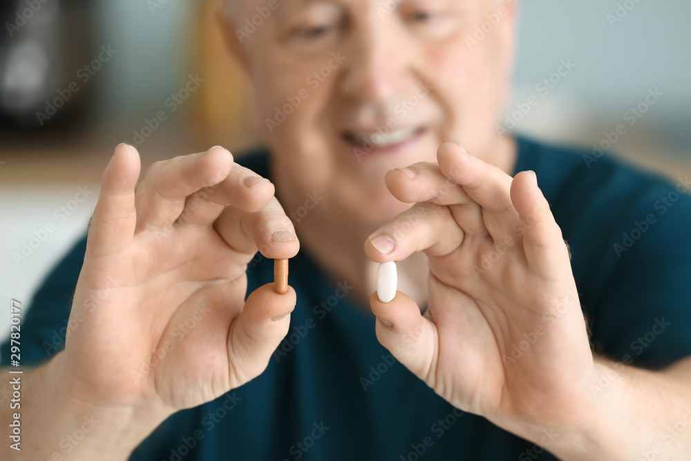 Elderly man with pills at home