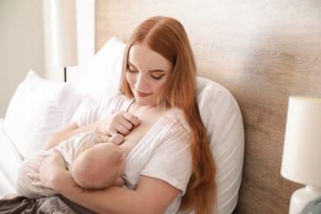 Wall Mural - Young woman breastfeeding her baby at home