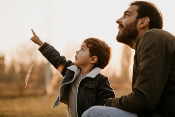 Wall Mural - Father and son having fun in autumn park.