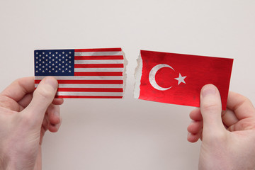 USA and Turkey paper flags ripped apart. political relationship concept