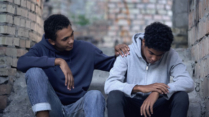 Afro-american teenager trying to make peace with friend, helping boy in need