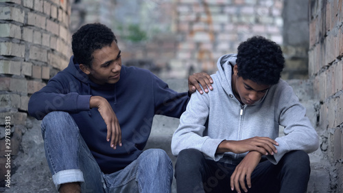 Cuadros en Lienzo Afro-american teenager trying to make peace with friend, helping boy in need