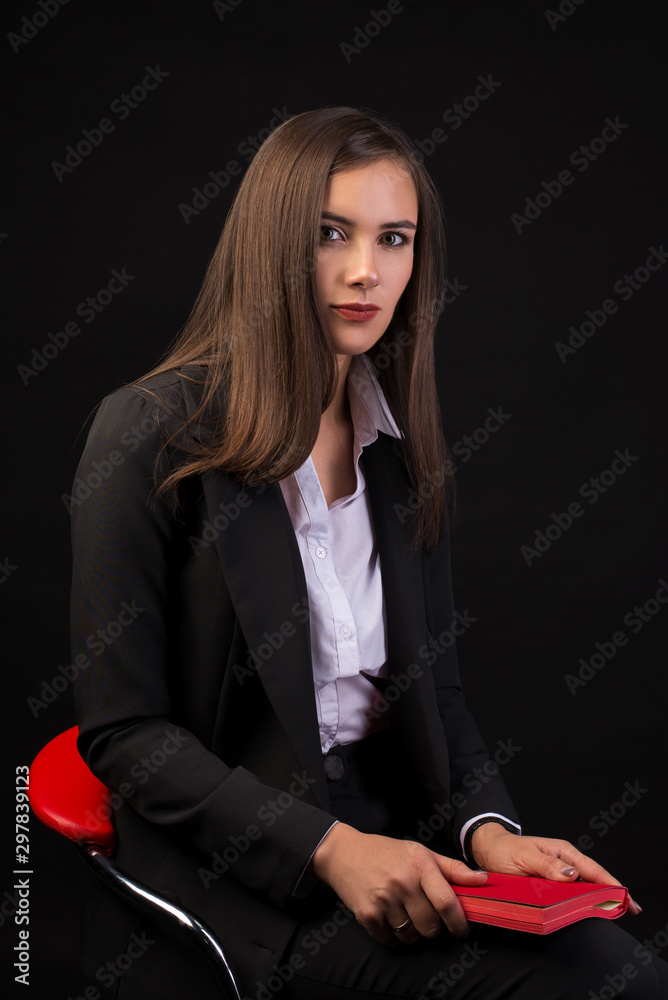 young beautiful girl with long black hair sitting on a red chair and ...