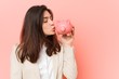 © Asier - Young caucasian woman holding a piggy bank