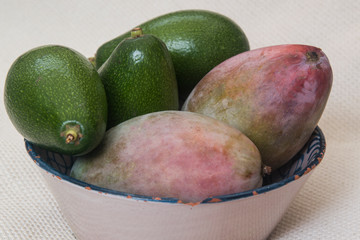 natural avocados and mangoes on white background