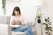© Prostock-studio - Young mother breastfeeding her baby on sofa at home