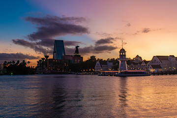 Wall Mural - Orlando, Florida. October 11, 2019. Colorful hotel, lighthouse and villas on colorful sunset background at Lake Buena Vista 52.