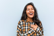 Young cool indian woman laughing keeping hands on heart, concept of happiness.