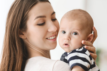 portrait of beautiful mother hugging her newborn child