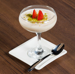 Strawberry dessert in glass on brown table