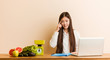 © Asier - Young nutritionist chinese woman working with her laptop pointing temple with finger, thinking, focused on a task.
