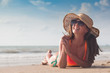 © el.rudakova - Beach woman funky happy and colorful wearing sunglasses and beach hat having summer fun during travel holidays vacation. Young trendy cool hipster woman in bikini lying in the sand.