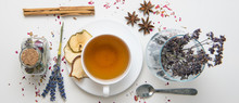 A White Mug On A White Table With Herbal Tea And Herbal Ingredients Laid Out On The Table. Concept On The Topic Of Herbal Treatment For Colds And Flu In Autumn. Top View