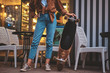 © Fxquadro - Trendy hipster woman is posing for photographer with her longboard near cafe.