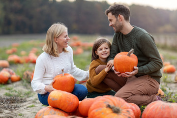 Wall Mural - Happy young family in pumpkin patch field