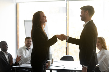 Wall Mural - happy proud female employee get promoted handshaking male boss manager