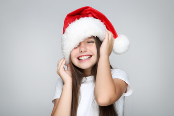little girl in christmas hat on grey background