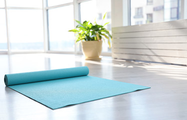 Canvas Print - Unrolled light blue yoga mat on floor in room