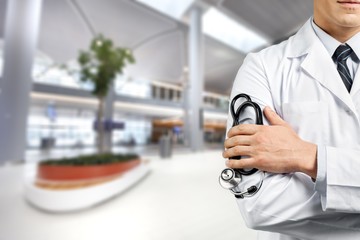 Wall Mural - Male doctor with stethoscope on blurred hospital background