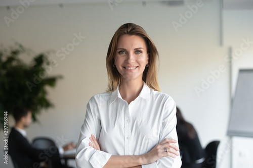Photographie Smiling female professional manager standing arms crossed looking at camera