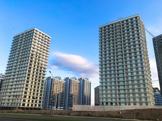 Tall beautiful monolithic-frame panel buildings, new buildings, skyscrapers, houses made of glass and concrete with many windows in the new district of the city. The background