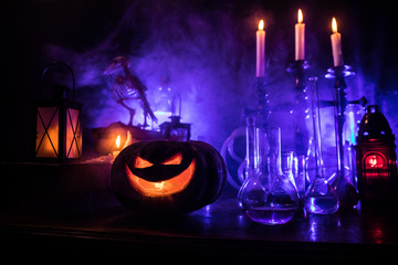 Halloween still-life background with different elements on dark toned foggy background. Selective focus