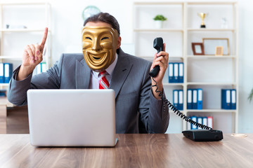 Businessman wearing mask in hypocrisy concept