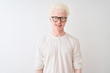© Krakenimages.com - Young albino blond man wearing t-shirt and glasses standing over isolated white background with a happy and cool smile on face. Lucky person.