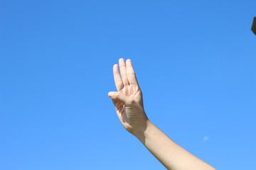 woman hand on blue sky background