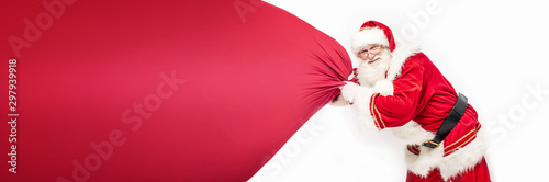 Fotomural Real Santa Claus pulling large red gift sack.