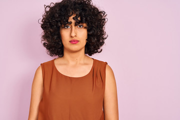 Sticker - Young arab woman with curly hair wearing t-shirt over isolated pink background with a confident expression on smart face thinking serious