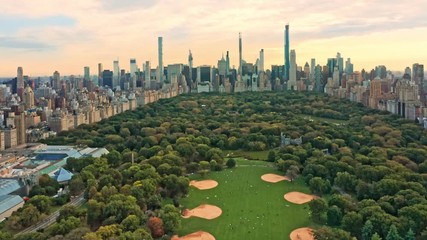 Fototapete - Aerial drone footage of New York midtown skyline at sunset viewed from above Central Park, with slow camera pull back