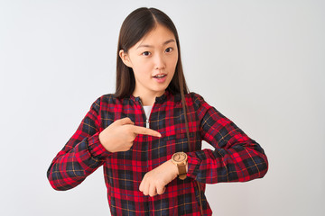 Poster - Young chinese woman wearing casual jacket standing over isolated white background In hurry pointing to watch time, impatience, upset and angry for deadline delay