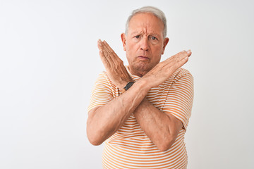 Canvas Print - Senior grey-haired man wearing striped t-shirt standing over isolated white background Rejection expression crossing arms doing negative sign, angry face