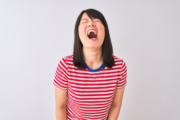 Wall Mural - Young beautiful chinese woman wearing red striped t-shirt over isolated white background angry and mad screaming frustrated and furious, shouting with anger. Rage and aggressive concept.