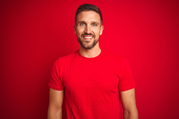 Sticker - Young handsome man wearing casual t-shirt over red isolated background with a happy and cool smile on face. Lucky person.