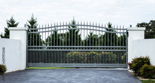 Fotografía Grey metal wrought iron driveway property entrance gates set in white concrete b