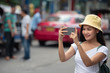 © May Chanikran - Happy traveller Asian woman on street market with smart phone camera, in Bangkok city of Thailand.