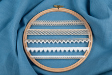 White Sewing Ribbons Set On Hoop Over Blue Background