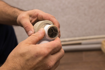 Preparing to connect the water supply. Winding the tape. Hands plumbing close-up.