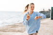 © Drobot Dean - Woman running outdoors on beach looking at watch clock.