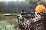 Hunter hold rifle  and aiming to deer.  Hunting optics equipment for professionals. Man aiming target. Leisure ir nature. Aiming skills.
