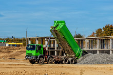 Construction Truck Tipping Dumping Gravel On Road Construction Site,tip Truck And Ripper At Work Preparing Ground For New Housing Estate,Dump Truck Unloading Process,
