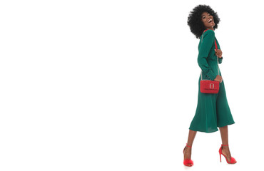 Perfect, total look of happy african woman in green dress and red accessories.